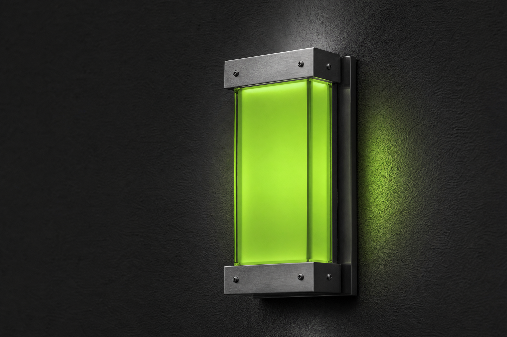 Dettaglio di un pannello in vetro smerigliato illuminato in verde lime su una parete nera