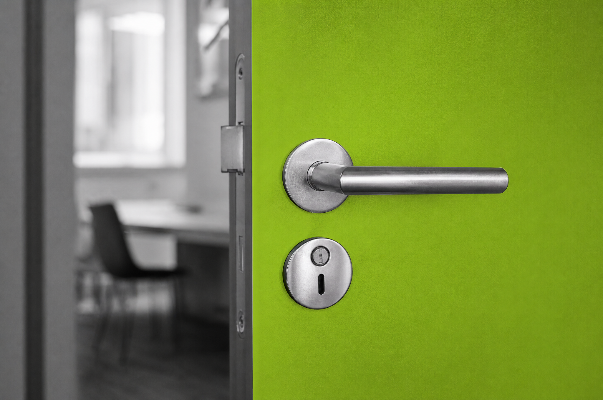 Primo piano sulla maniglia di una porta verde lime